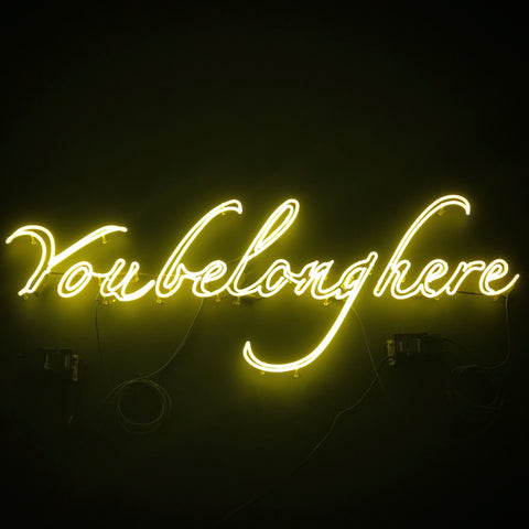 "You belong here" in script neon lights