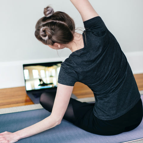 Unsplash image of woman doing yoga at home in front of her laptop